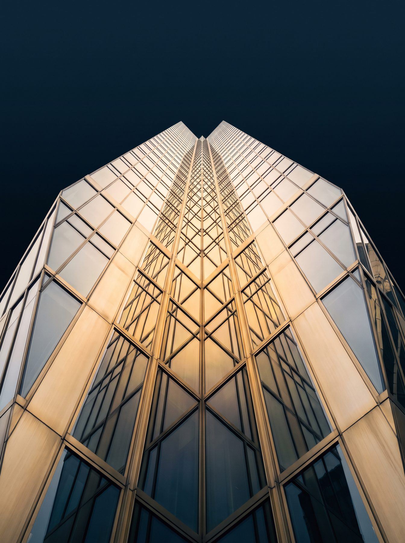 Looking up at a modern glass skyscraper facade in Dubai's financial district